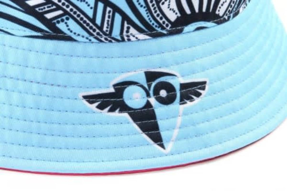 A blue and patterned reversible bucket hat featuring a logo on the side. The inside has a contrasting colour.