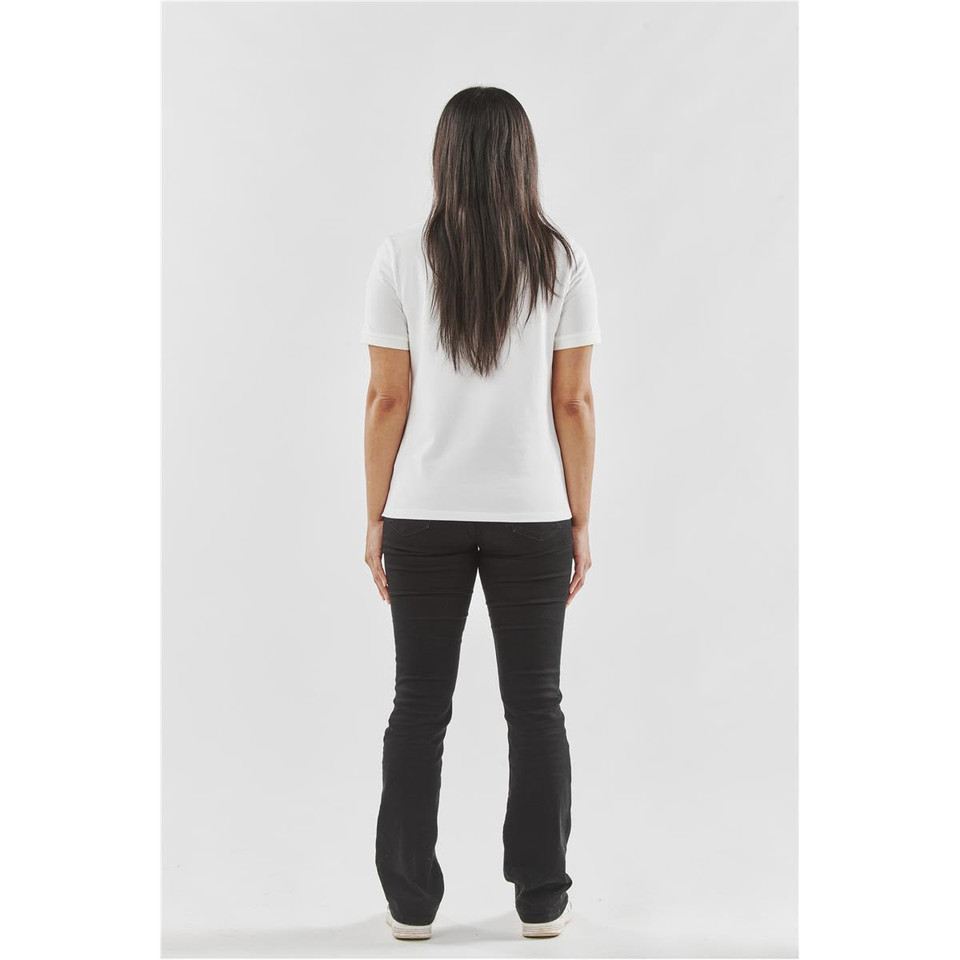 A woman wearing a white women's Ferrera polo shirt, viewed from the back, paired with black pants.