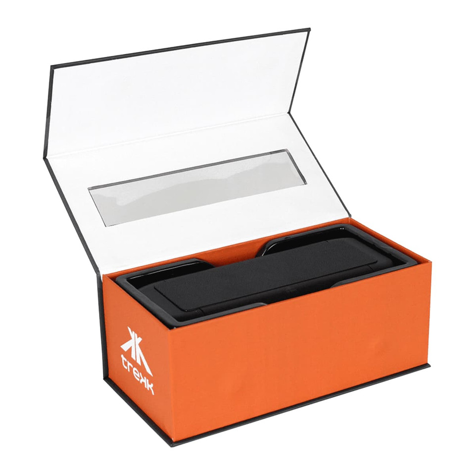 A black outdoor speaker and wireless power bank in an open orange box with a clear plastic window and branding.