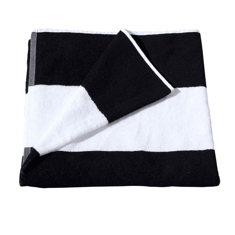 A folded cotton beach towel featuring bold black and white stripes, with one corner tucked. It has a logo.