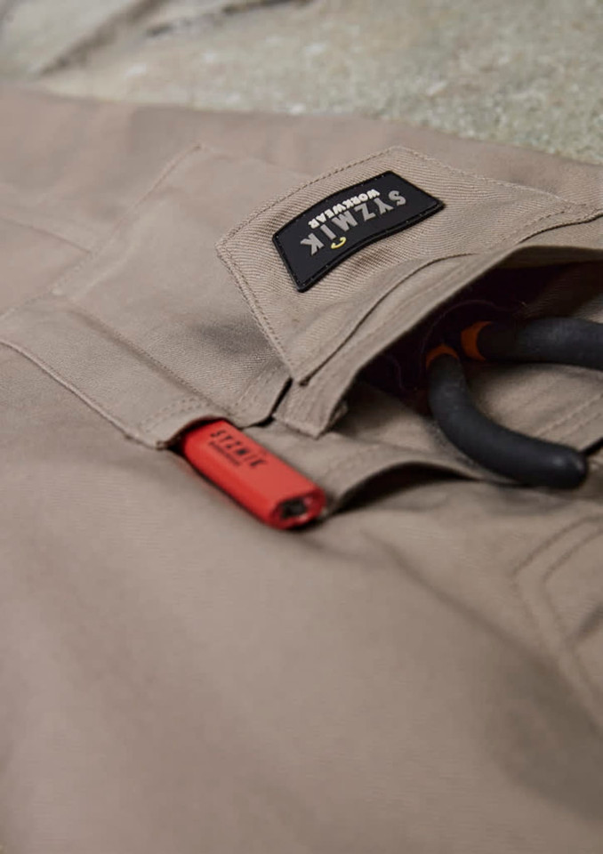 Rugged cooling stretch cargo pants in beige with a logo patch and tool loops.
