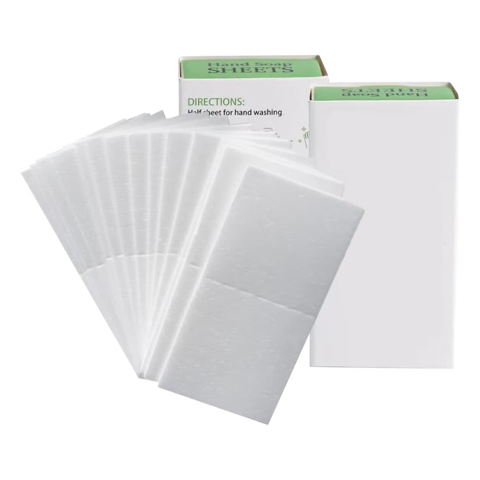 A pack of white travel paper soap sheets displayed beside their packaging. The product has a simple design with a logo.