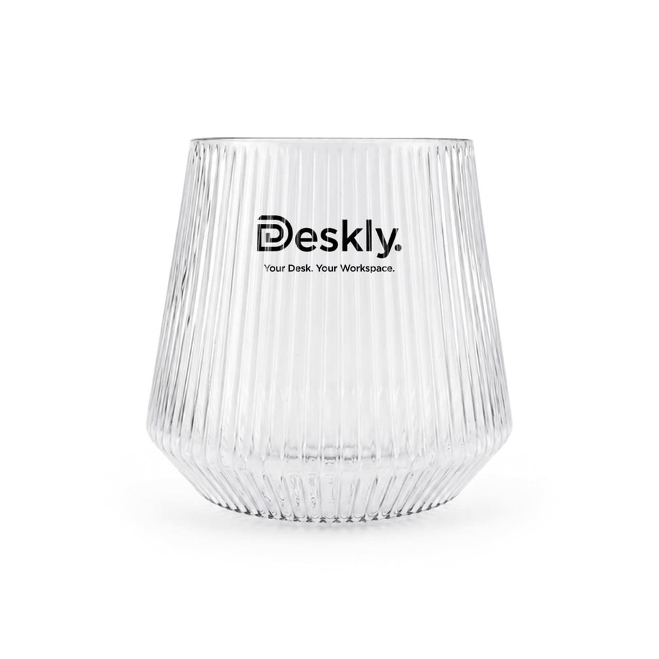 A clear glass tumbler with ribbed texture and a logo at the front.