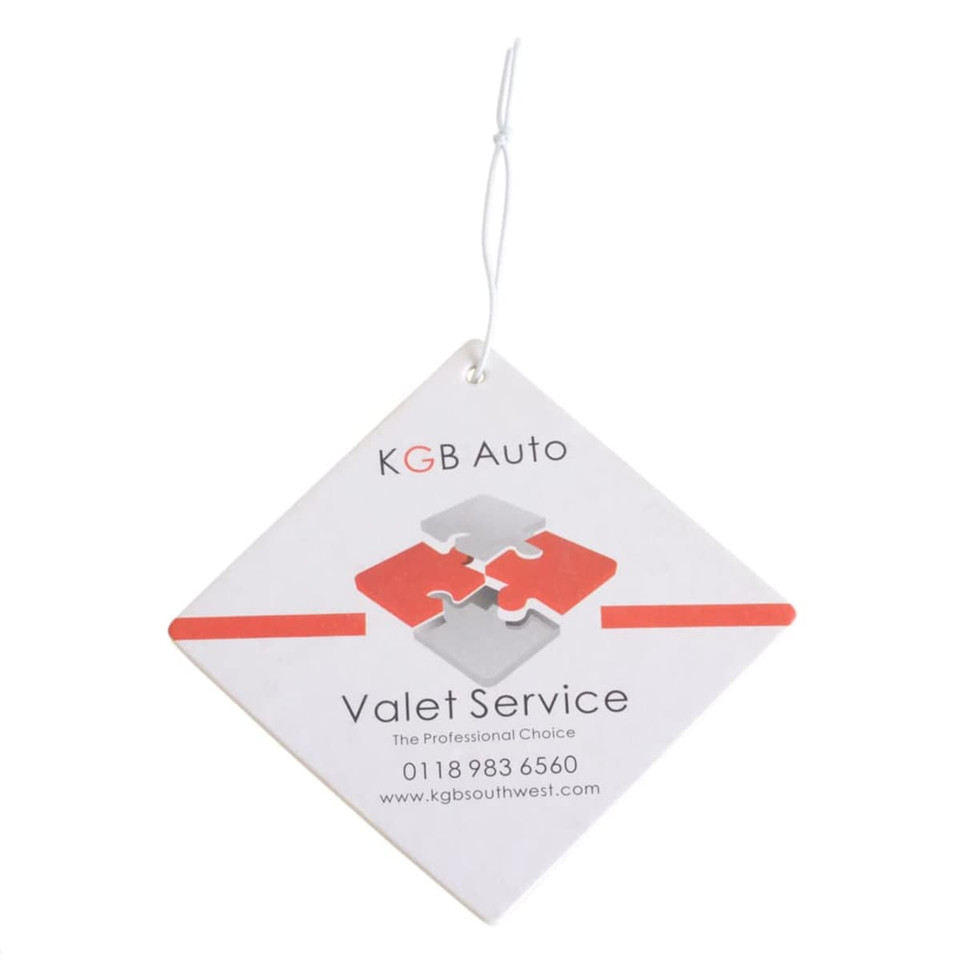 A square air freshener in white with red and grey puzzle design, featuring a hanging string and a logo.