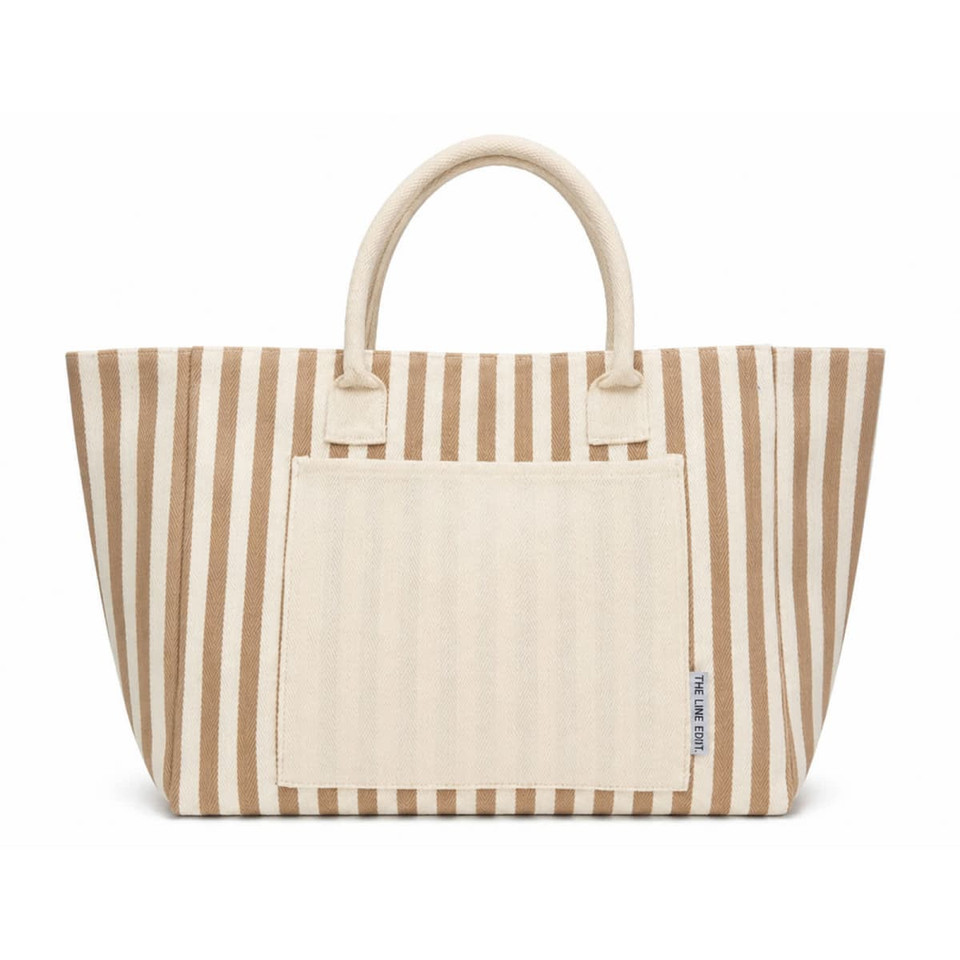 A striped tote bag in beige and cream featuring two handles and a front pocket. Branding is present on the bag.