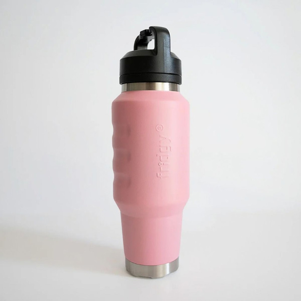 Angled front view of a light pink insulated 1L water bottle showcasing textured finger-grip contours, stainless steel base accents, and an integrated carry-handle lid.