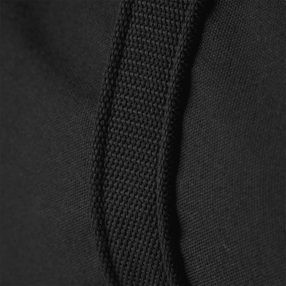 Close-up of a black duffel bag featuring textured fabric and sturdy stitching along the strap.