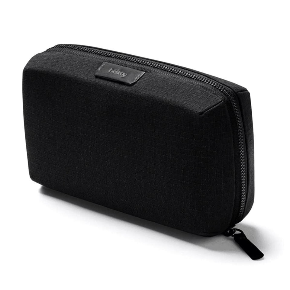 A black tech kit with a rectangular shape, featuring a textured surface and a zipper closure. It has a branding logo.