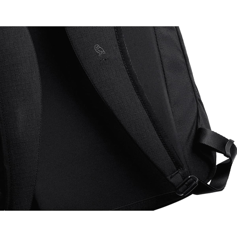 A black backpack interior featuring a textured lining and adjustable straps, with a logo on the inner fabric.