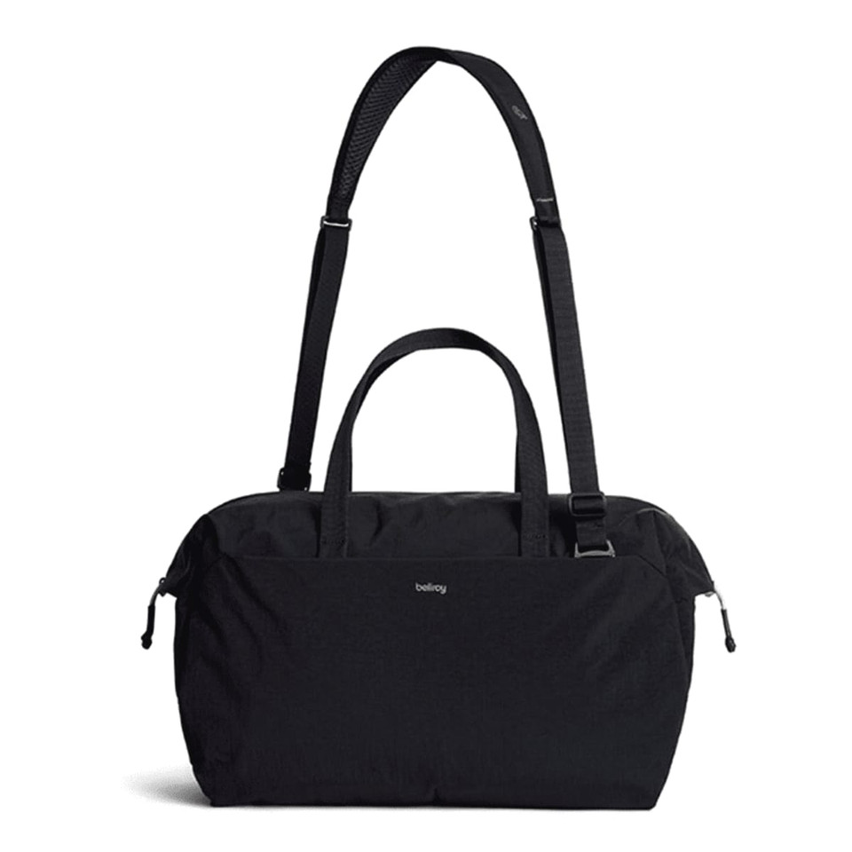 A black duffel bag with a detachable strap and dual handles, featuring a logo on the front.