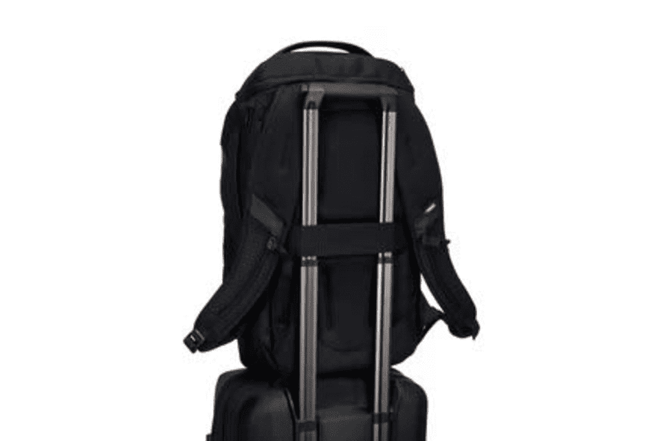 A black backpack with straps, designed to fit securely on a wheeled suitcase, featuring a logo.