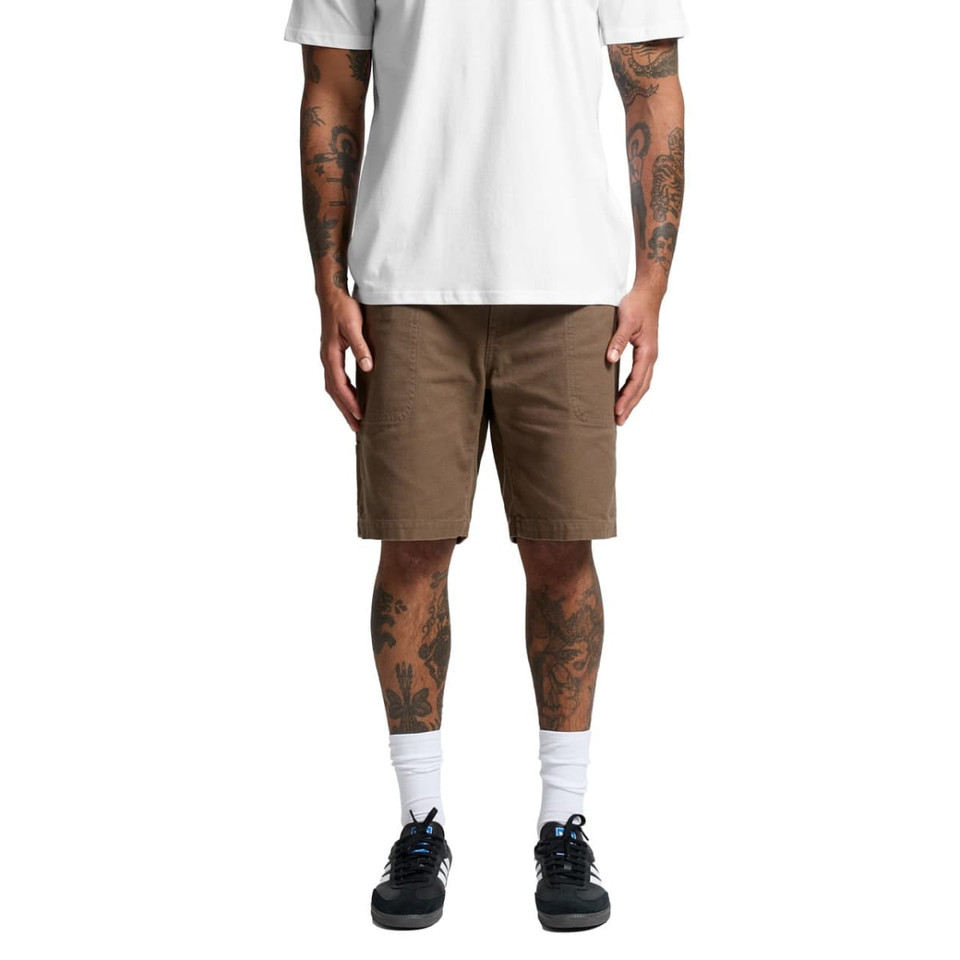 Cotton cargo shorts in a light brown colour, featuring multiple pockets, worn by a person with tattoos.