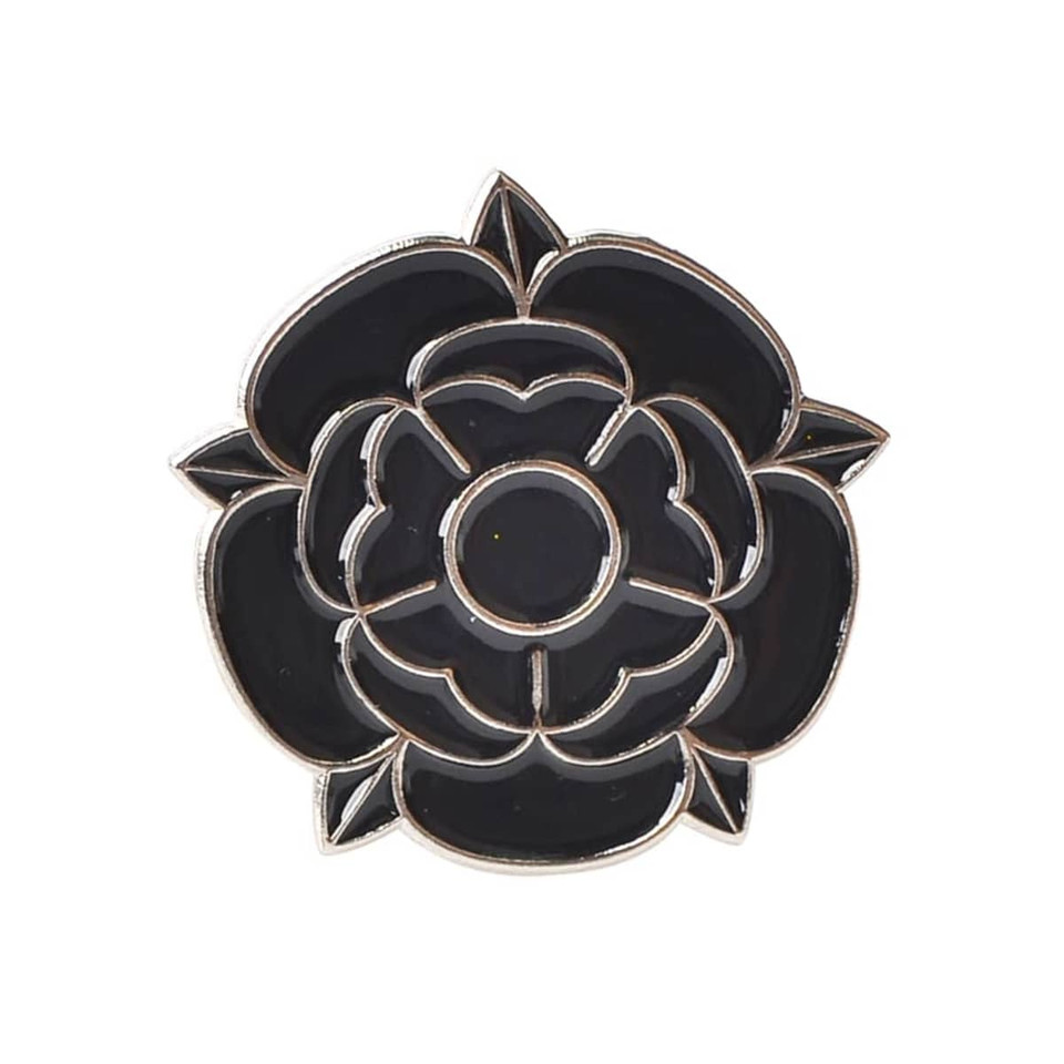 A black rose-shaped lapel pin with a silver outline and detailing, featuring an embedded logo.
