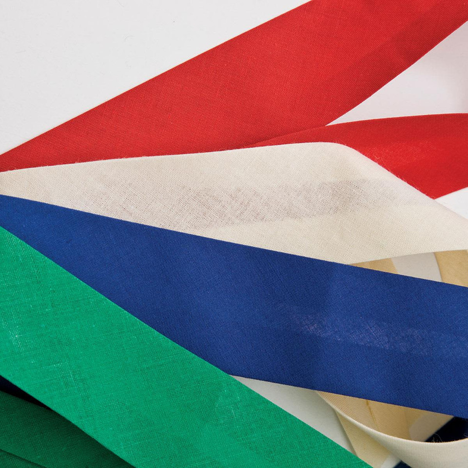 A collection of ribbon strips in red, white, blue, green, and cream laid out on a white background.