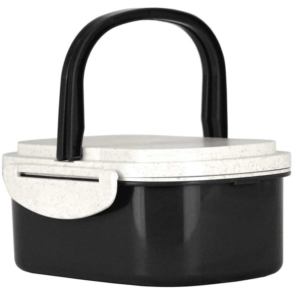 A plastic and wheat straw lunch box in black and white with a handle and a secure lid. It features a logo.