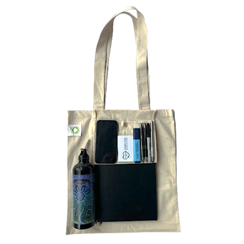 Eco-friendly tote bag with stationery, notebook, water bottle, and smartphone.