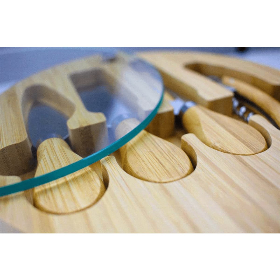 A bamboo cheese board featuring a glass top and compartments for cheese knives. The board has a natural wood finish.