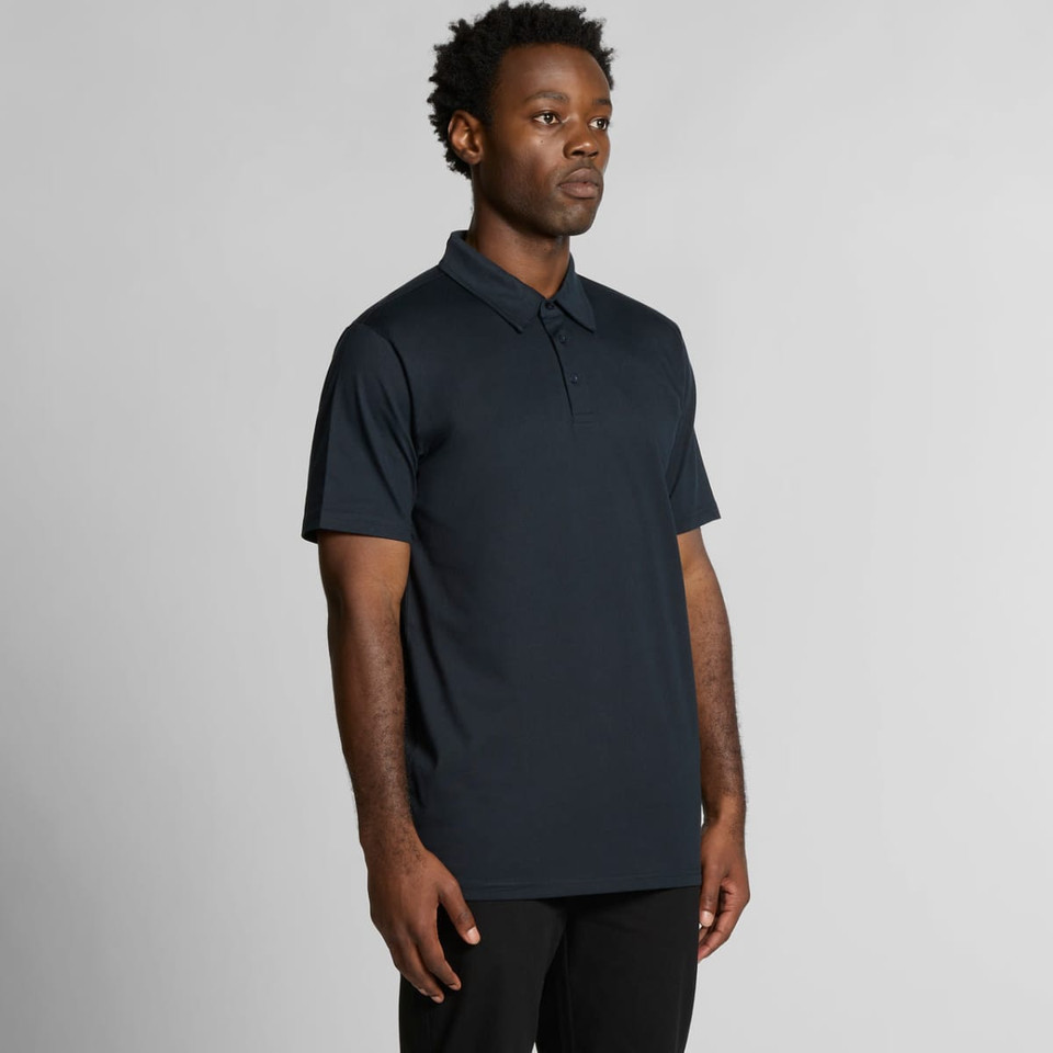 A black polo shirt on a model, featuring a collar and short sleeves, with a logo on the chest.