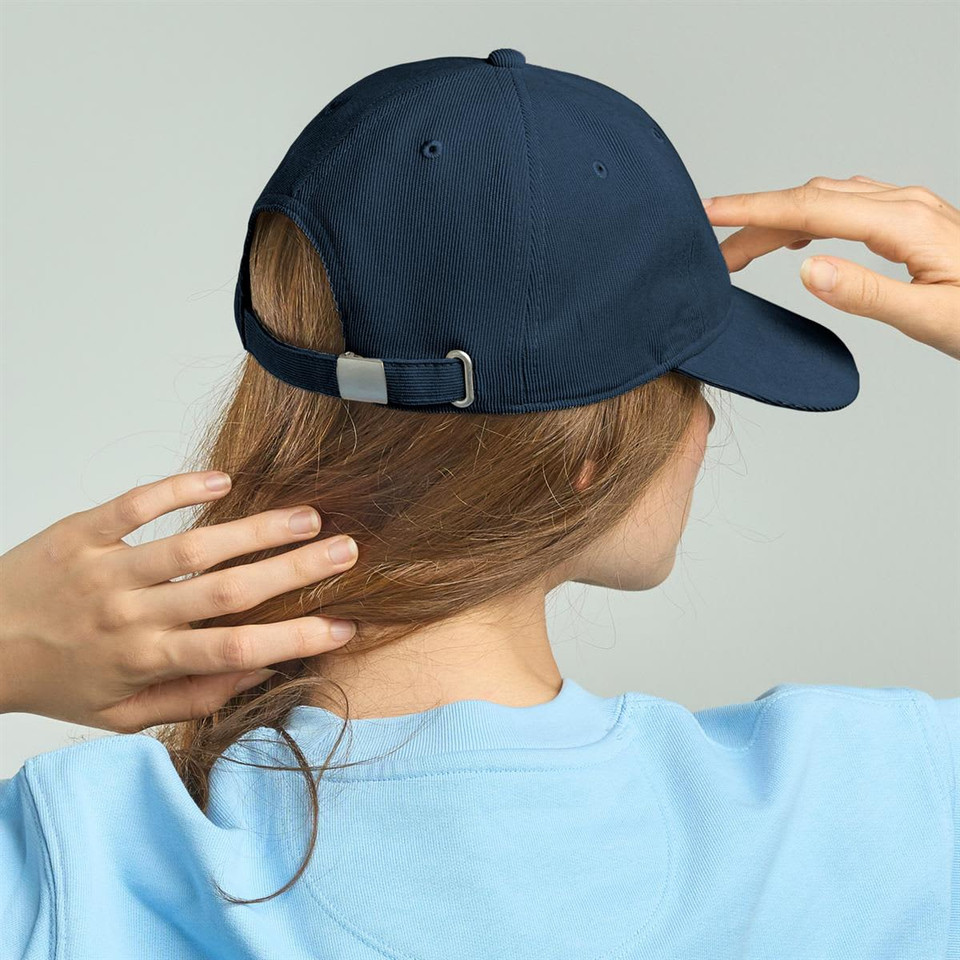 A blue recycled corduroy cap with an adjustable strap, viewed from behind on a model.