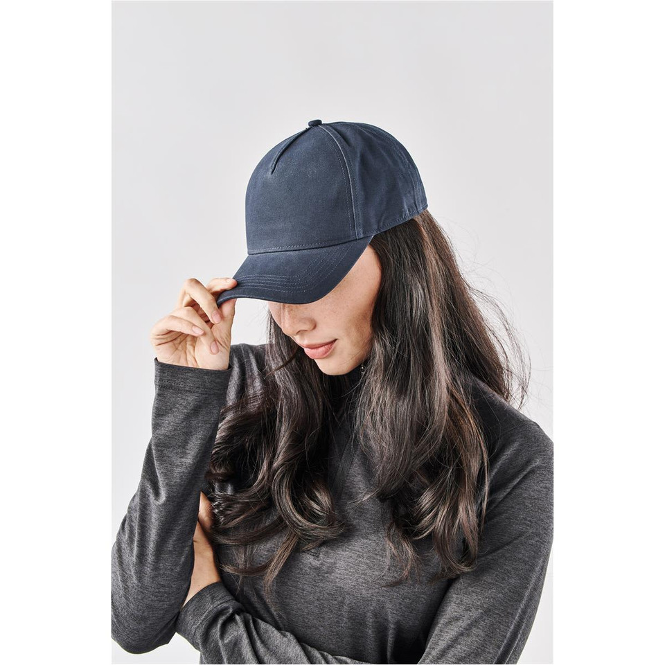 A navy Explorer Cap displayed on a model with long hair, featuring a simple design and a logo.