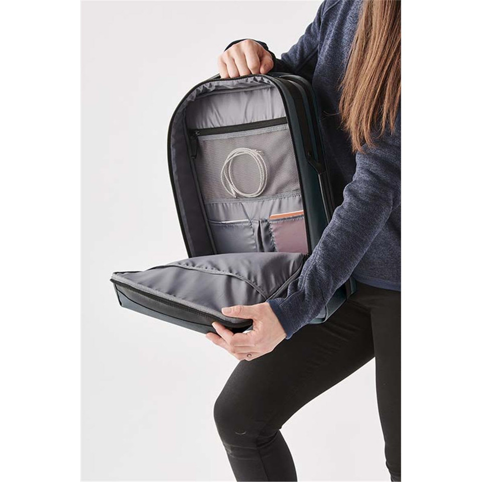 A person holding the open Hedmark Commuter Backpack, featuring a grey interior and multiple compartments.