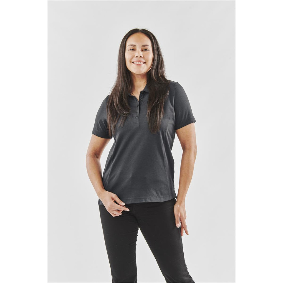 A black women's polo shirt with a collar, featuring a subtle logo, on a model standing against a neutral background.