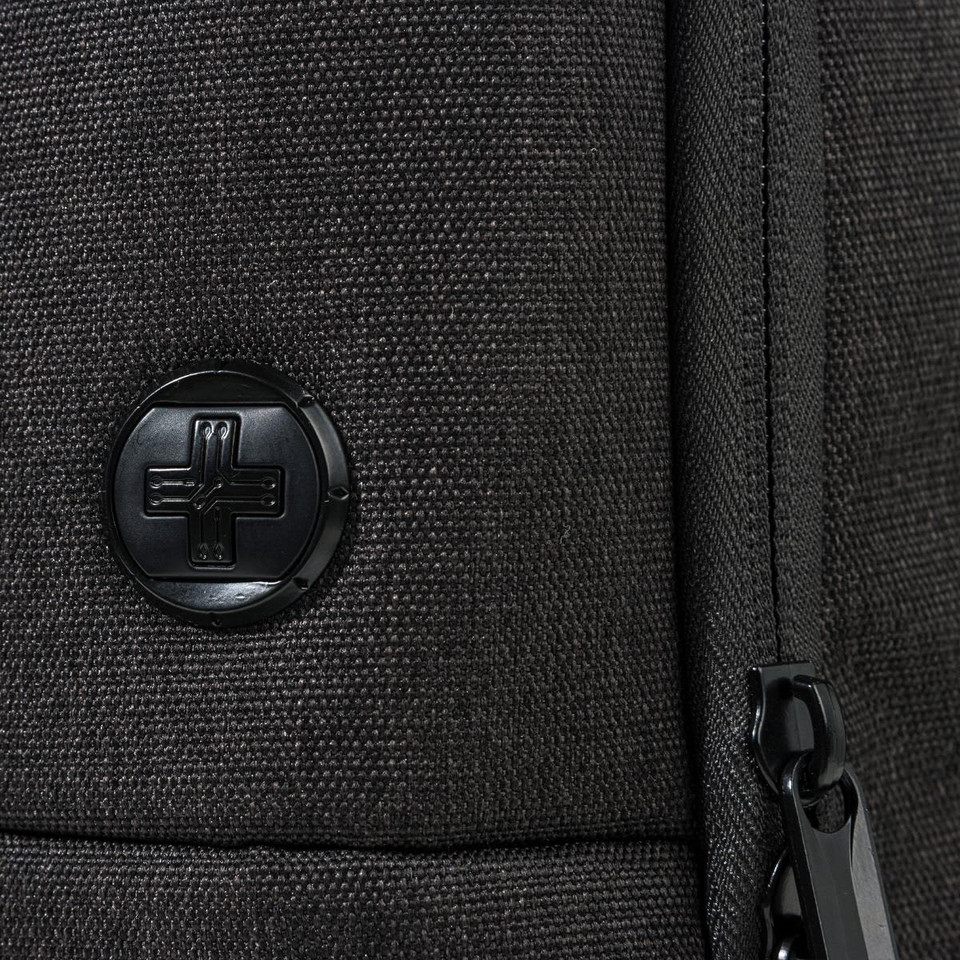 A black backpack featuring a textured surface and a round logo. The zipper detail is also visible.