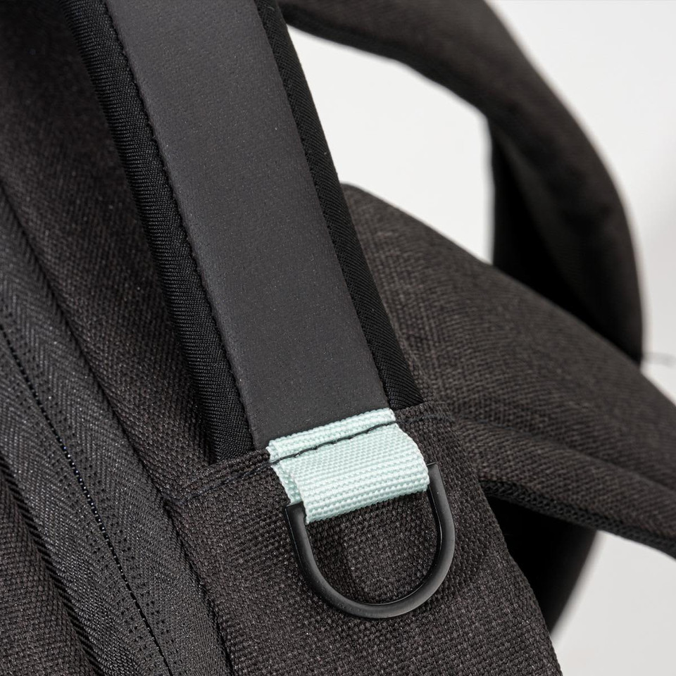 A black backpack strap featuring a light blue accent and a metal loop. The material has a textured finish.