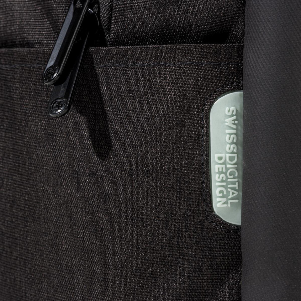 A close-up of a black backpack featuring a textured fabric and a logo patch.