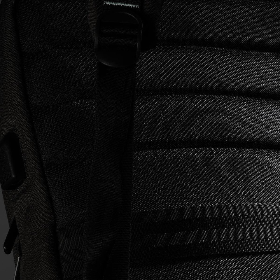 A black backpack featuring textured fabric and adjustable straps, with a logo on the side.