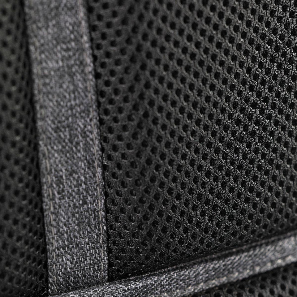 Black mesh fabric detail with stitching from a backpack, featuring a textured pattern and reinforcement tape.