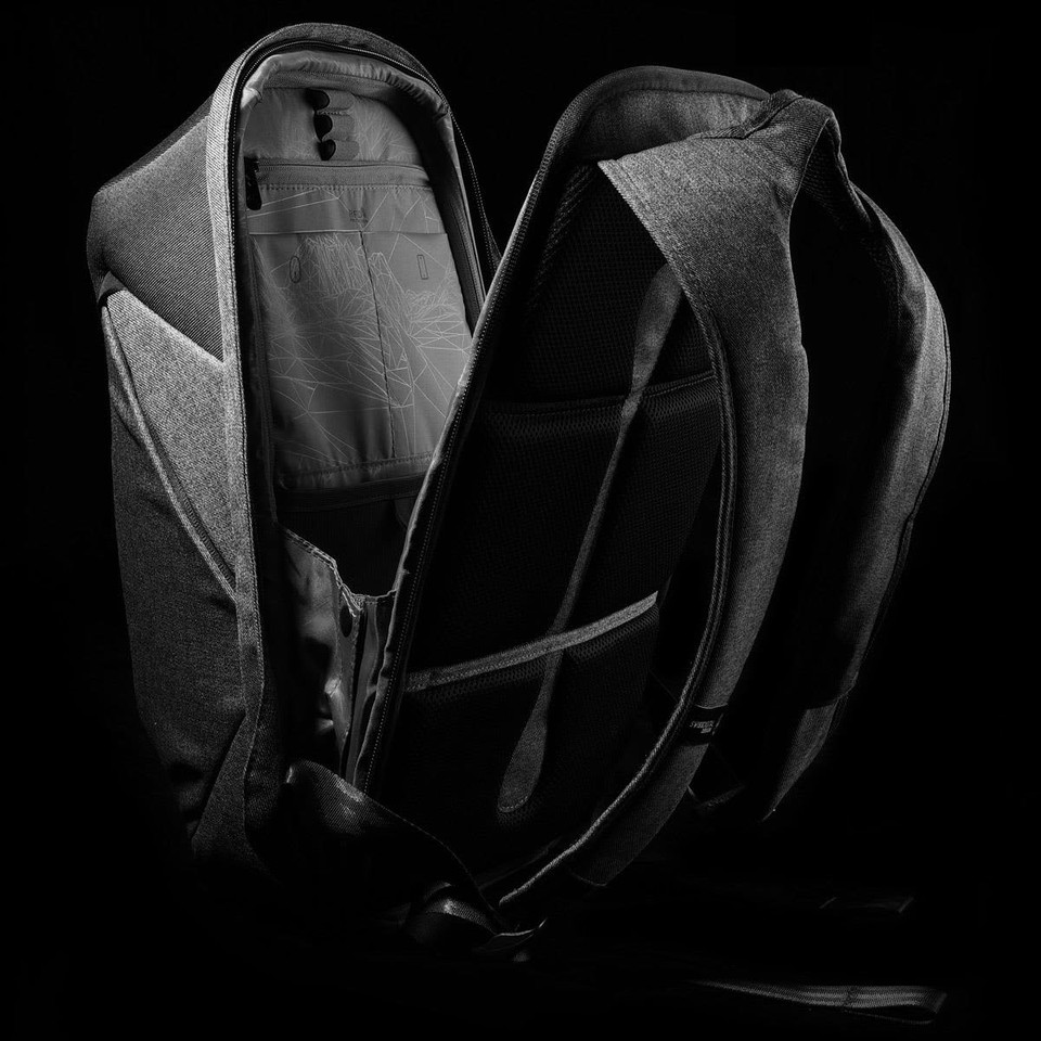 A grey backpack with a sleek design, featuring multiple compartments and a logo on the exterior.