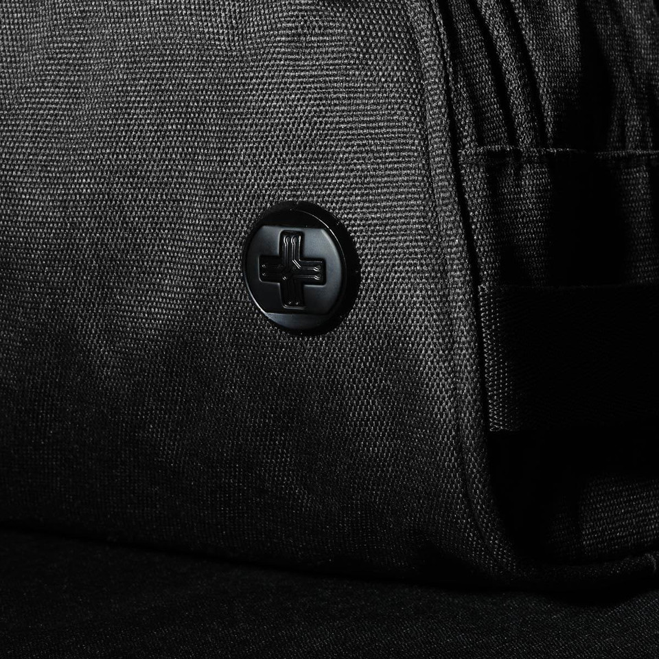 A black wash bag featuring a textured fabric and a logo button. Ideal for toiletries and accessories.