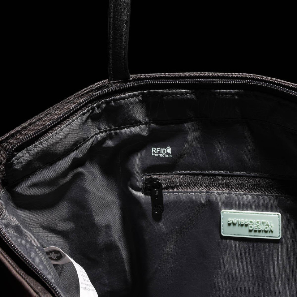 An interior view of a black tote bag featuring RFID protection, a zip pocket, and branding.