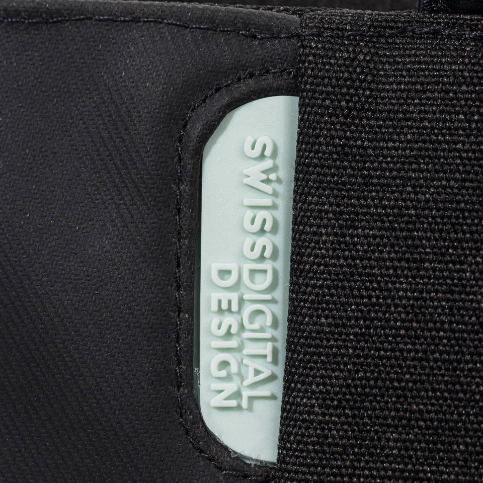 A black tote bag featuring a light blue branding label, made with a durable fabric.
