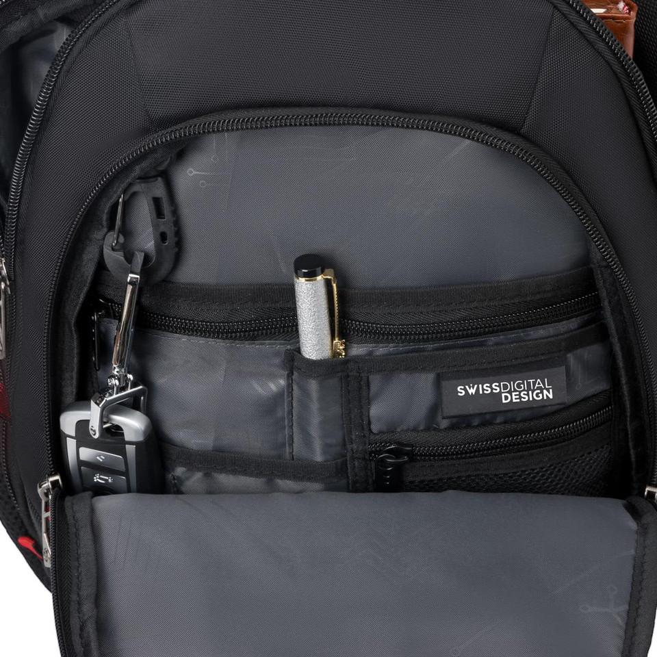 An inner pocket of a black backpack featuring compartments for a pen, keys, and a small device.