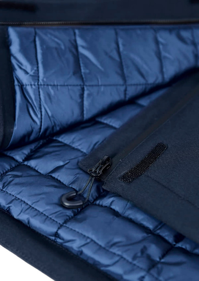 A navy blue insulated jacket interior features quilted lining and a zippered pocket. Includes a logo on the exterior.
