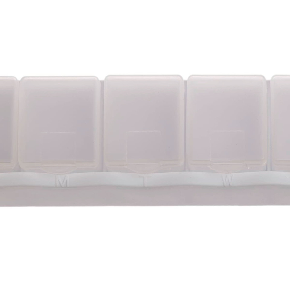 A weekly pill box in translucent white plastic with compartments labeled for each day of the week.