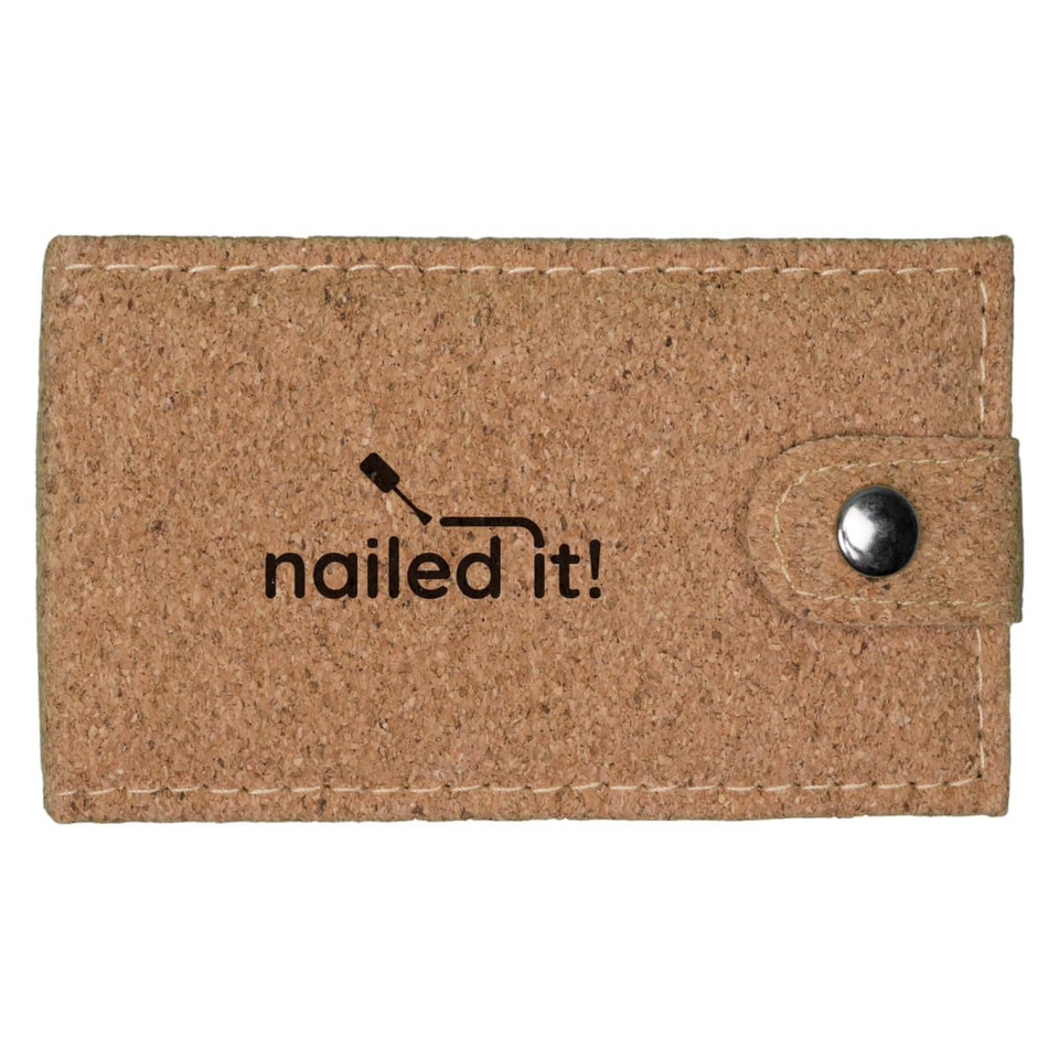 A cork manicure set in a beige case with a button closure and a logo printed on the front.