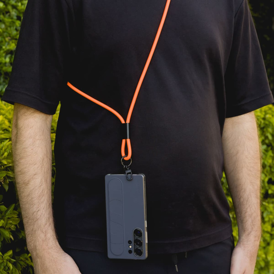 A phone lanyard in orange with a black attachment holding a smartphone, worn around a person's neck.
