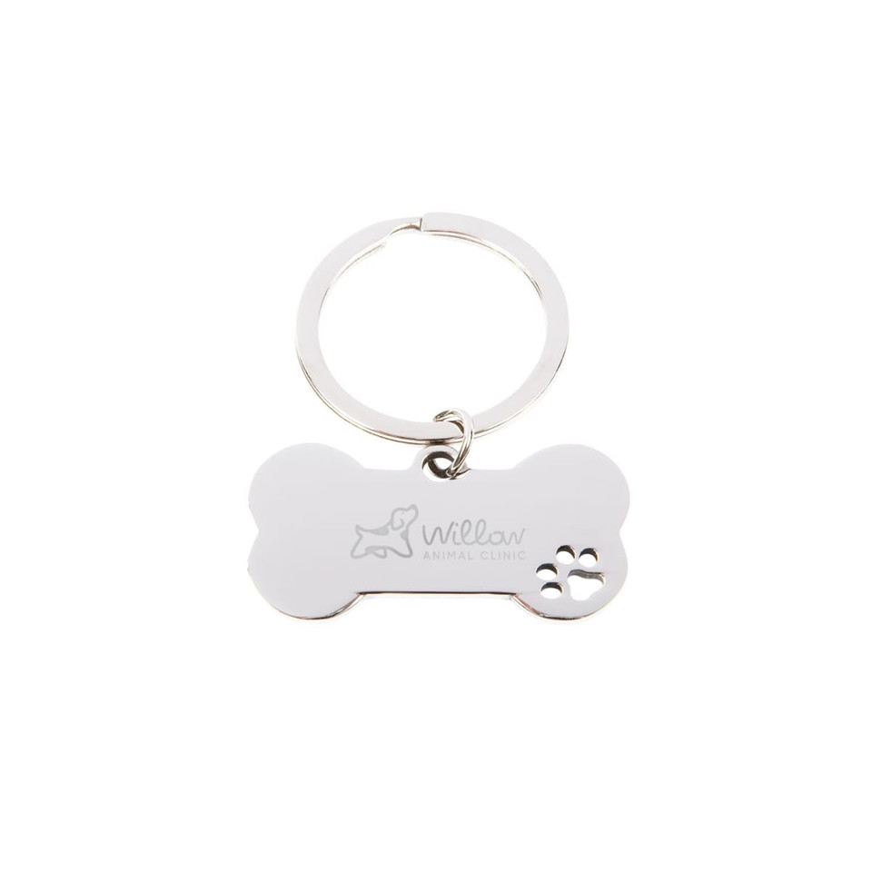 A metallic dog bone keytag with a keyring, featuring a logo and a paw print design.
