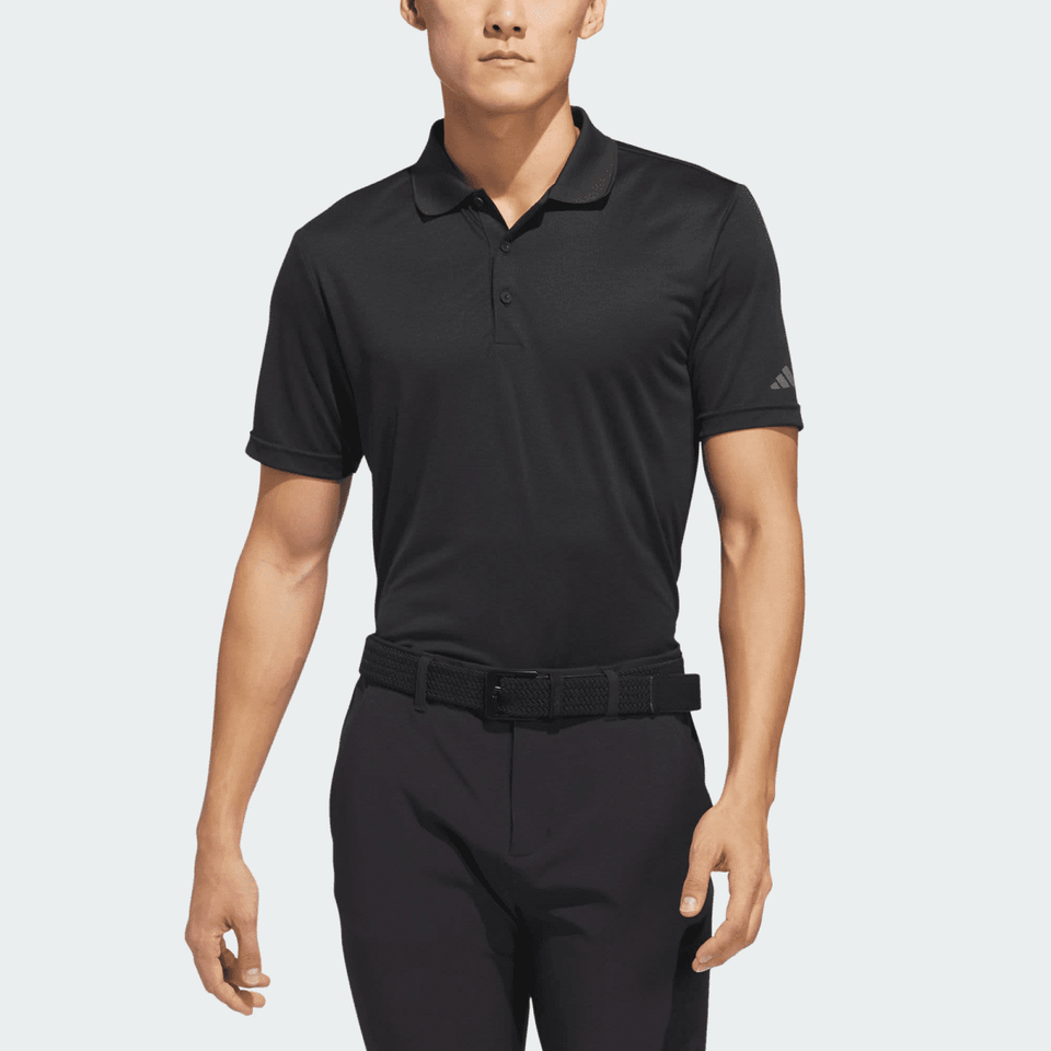A black Adidas men's recycled performance polo shirt featuring a logo, worn with black trousers and a belt.
