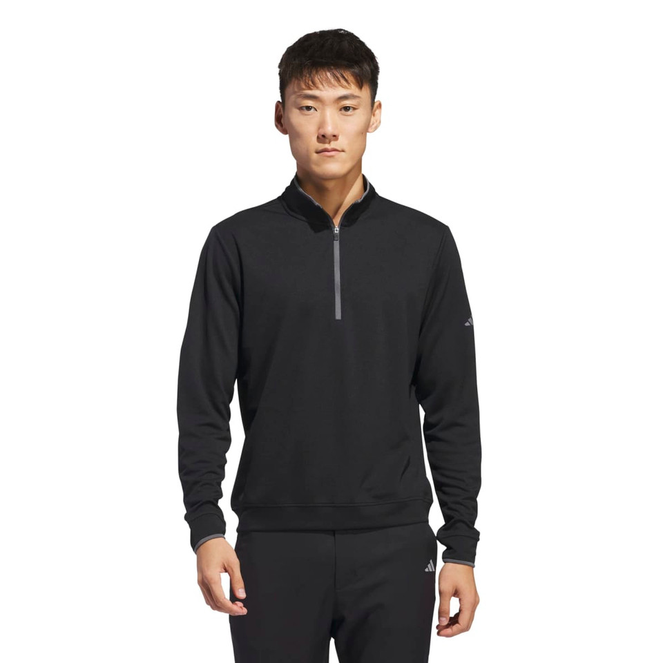 A black lightweight quarter zip pullover for men, featuring a logo on the sleeve. Suitable for casual wear.
