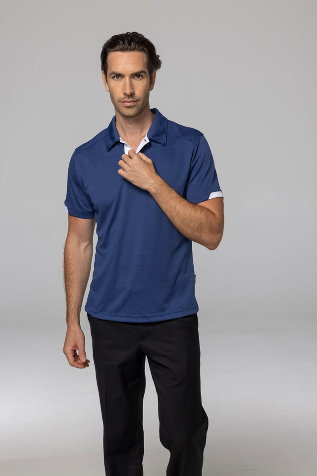 A man wearing a navy blue polo shirt with a logo, paired with dark trousers.
