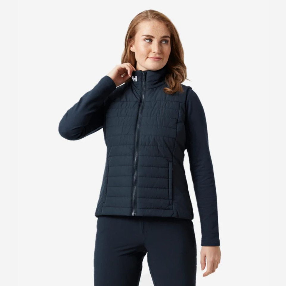 Woman wearing a black quilted Helly Hansen vest with a high collar against a white background.