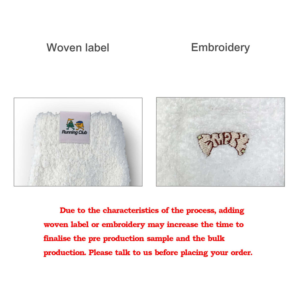 A pair of white coral fleece socks with a woven label and embroidered detailing. Footwear product for promotional use.