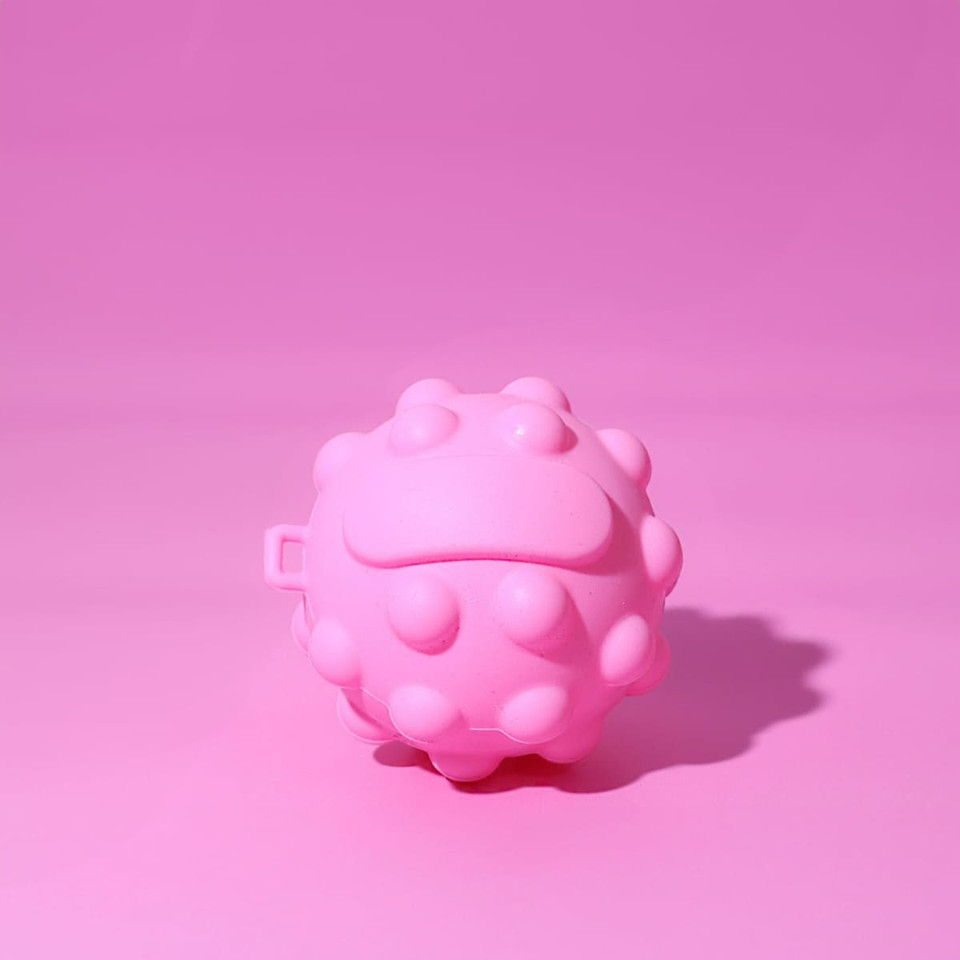 A pink, textured stress ball in a rounded shape with small protrusions, set against a pink background.