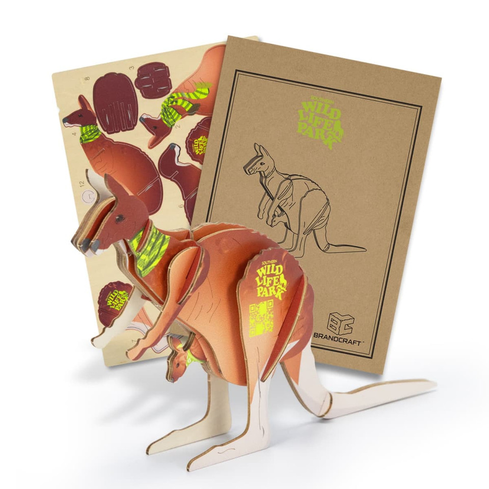 A wooden kangaroo model featuring brown tones and a box with colourful designs. It has a logo on the packaging.