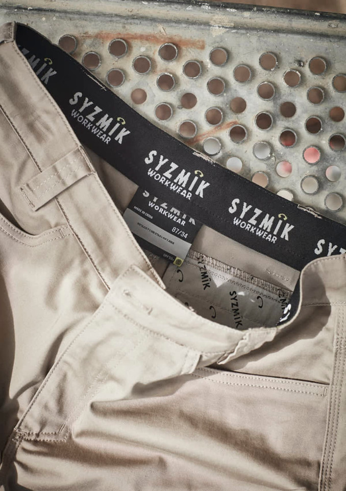 A pair of beige cargo shorts with a branded waistband, featuring multiple pockets and a casual design.