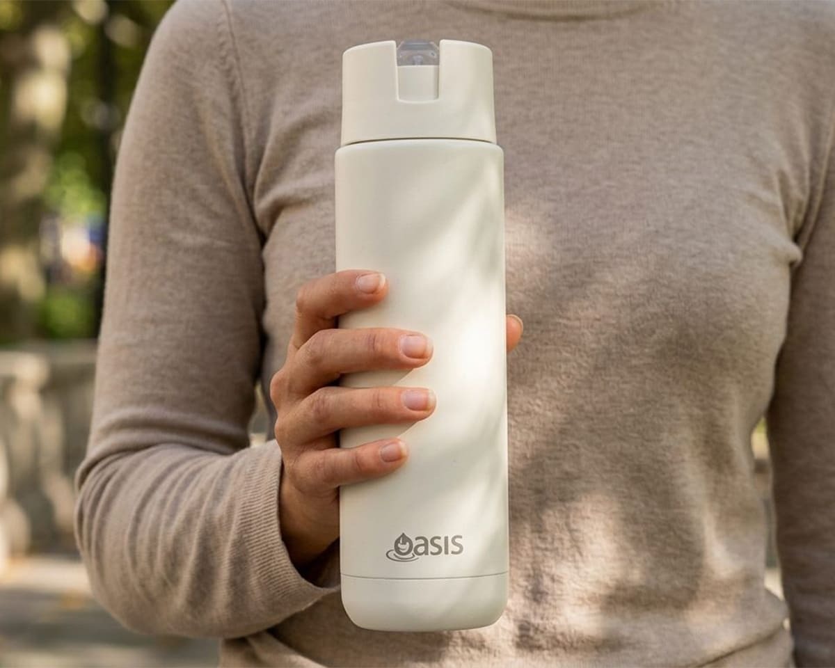 Close-up of a woman holding an Oasis water bottle